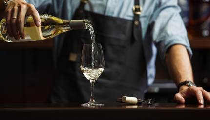 Bartender serving white wine