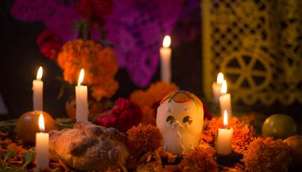 Sugar skull with candles, bread and flowers decoration