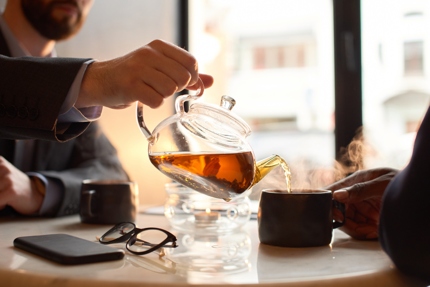 Two men sharing a pot of tea