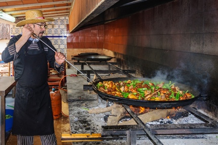 A Valencian chef making paella for a party