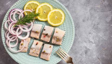 Arenque en escabeche con rodajas de limón y cebollas rojas