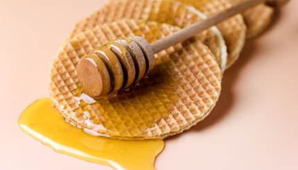 Stroopwafels a tetején pihenő mézes rúddal