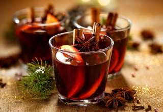 Glasses of mulled wine with orange slices and cinnamon sticks