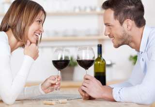 Happy couple enjoying a glass of wine each
