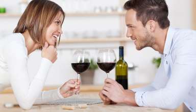 Happy couple enjoying a glass of wine each