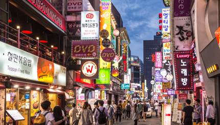 Busy street lined with restaurants in the Myeong-dong district at night