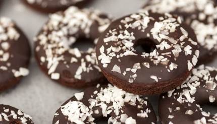 Vegan gluten free chocolate covered cake doughnuts with coconut sprinkles